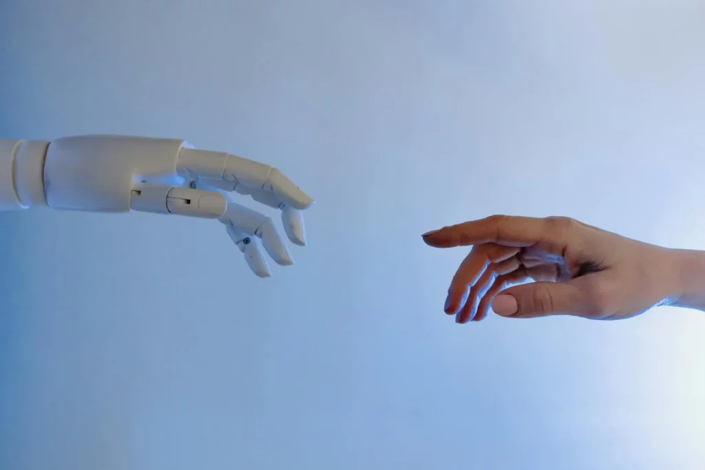 Interaction entre une main humaine et une main robot illustrant l’intelligence artificielle et la gestion des risques en entreprise